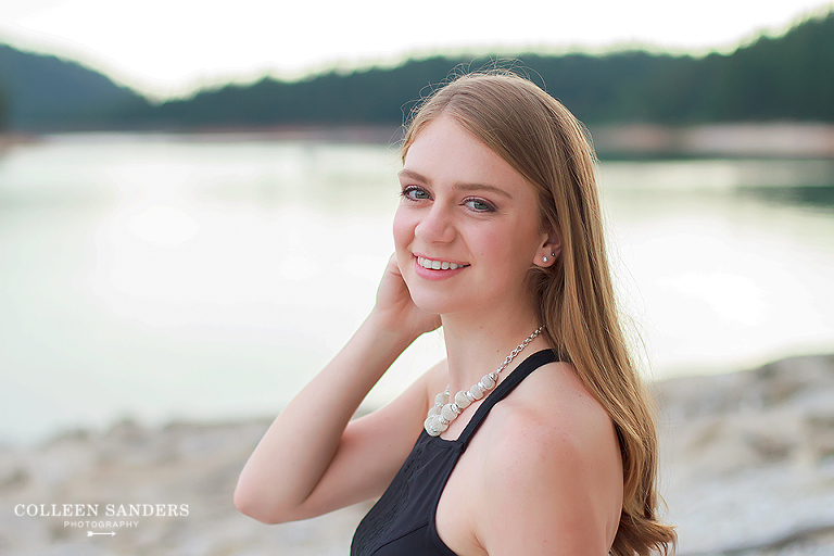 Classic high school senior portraits with one of her senior models by the lake with natural greenery and a hat by senior photographer Colleen Sanders near El Dorado Hills, California.