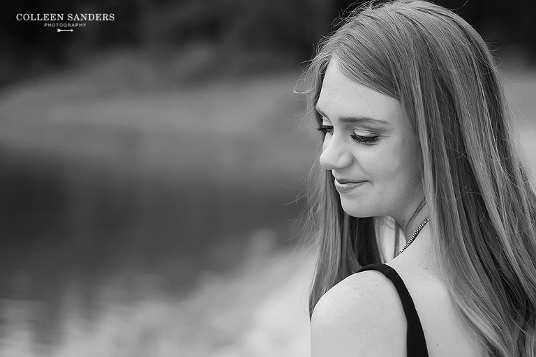 Classic high school senior portraits with one of her senior models by the lake with natural greenery and a hat by senior photographer Colleen Sanders near El Dorado Hills, California.