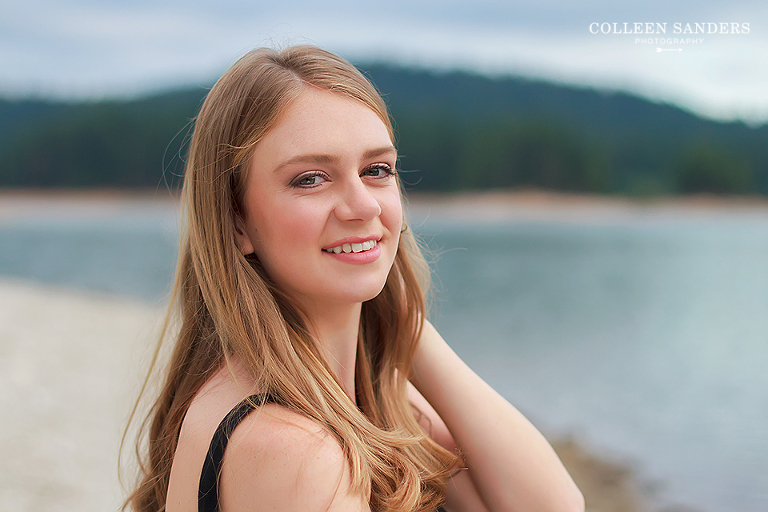 Classic high school senior portraits with one of her senior models by the lake with natural greenery and a hat by senior photographer Colleen Sanders near El Dorado Hills, California.