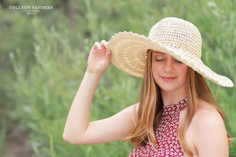 Classic high school senior portraits by the lake with natural greenery and a hat by senior photographer Colleen Sanders near El Dorado Hills, California.