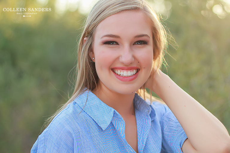 Classic high school senior portraits by the lake with natural greenery and a hat by senior photographer Colleen Sanders near El Dorado Hills, California.