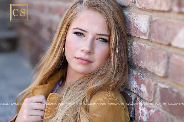 Oak Ridge High School senior Hannah leaning against a brick wall with mustard yellow jacket by El Dorado Hills Senior Photographer Colleen Sanders.